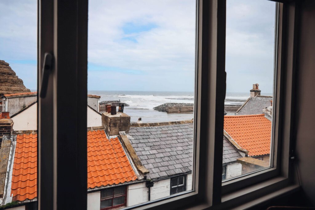 An ocean view from the window of a bedroom.