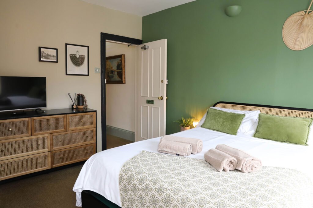Bedroom with bed, dresser, and TV.
