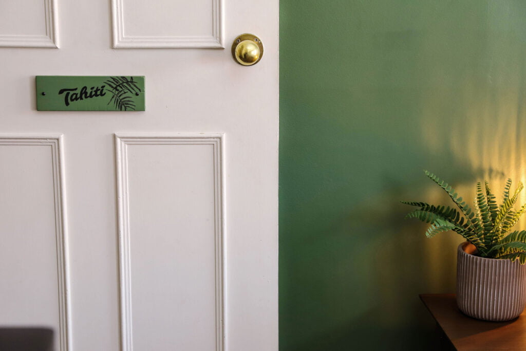 A white door with a green sign reading 'Tahiti'.