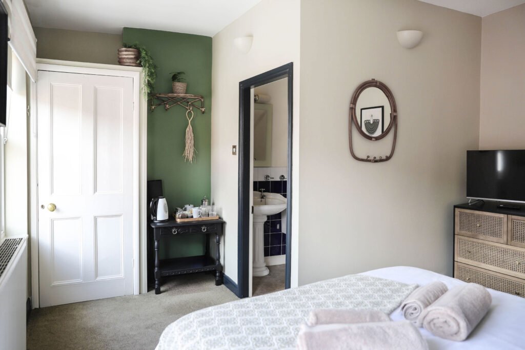 Cozy bedroom with bed, TV, mirror with a boho decor.