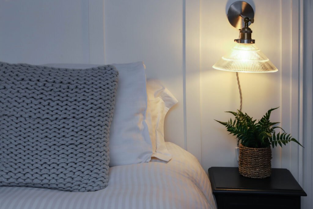 A bedside lamp illuminating the bedroom.