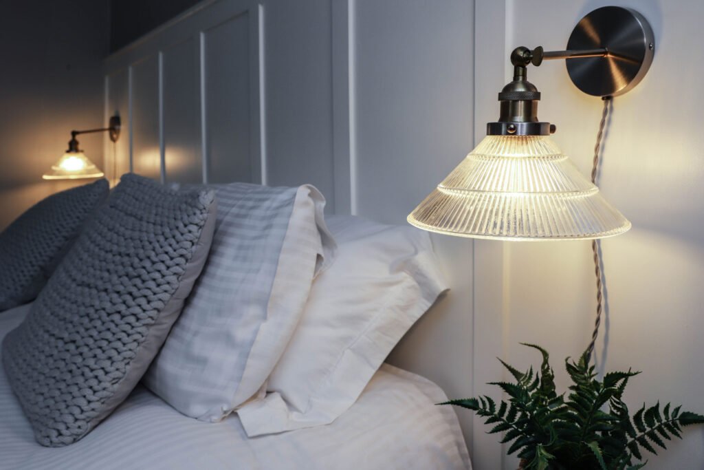 A bedside lamp illuminating the bedroom with warm light.