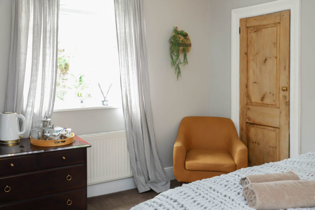 A cosy chair in the corner of a bedroom.