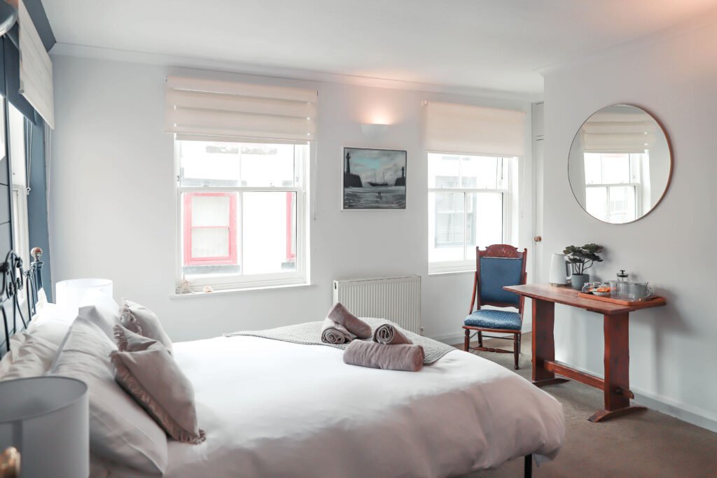 A light and airy bedroom with wooden furniture.